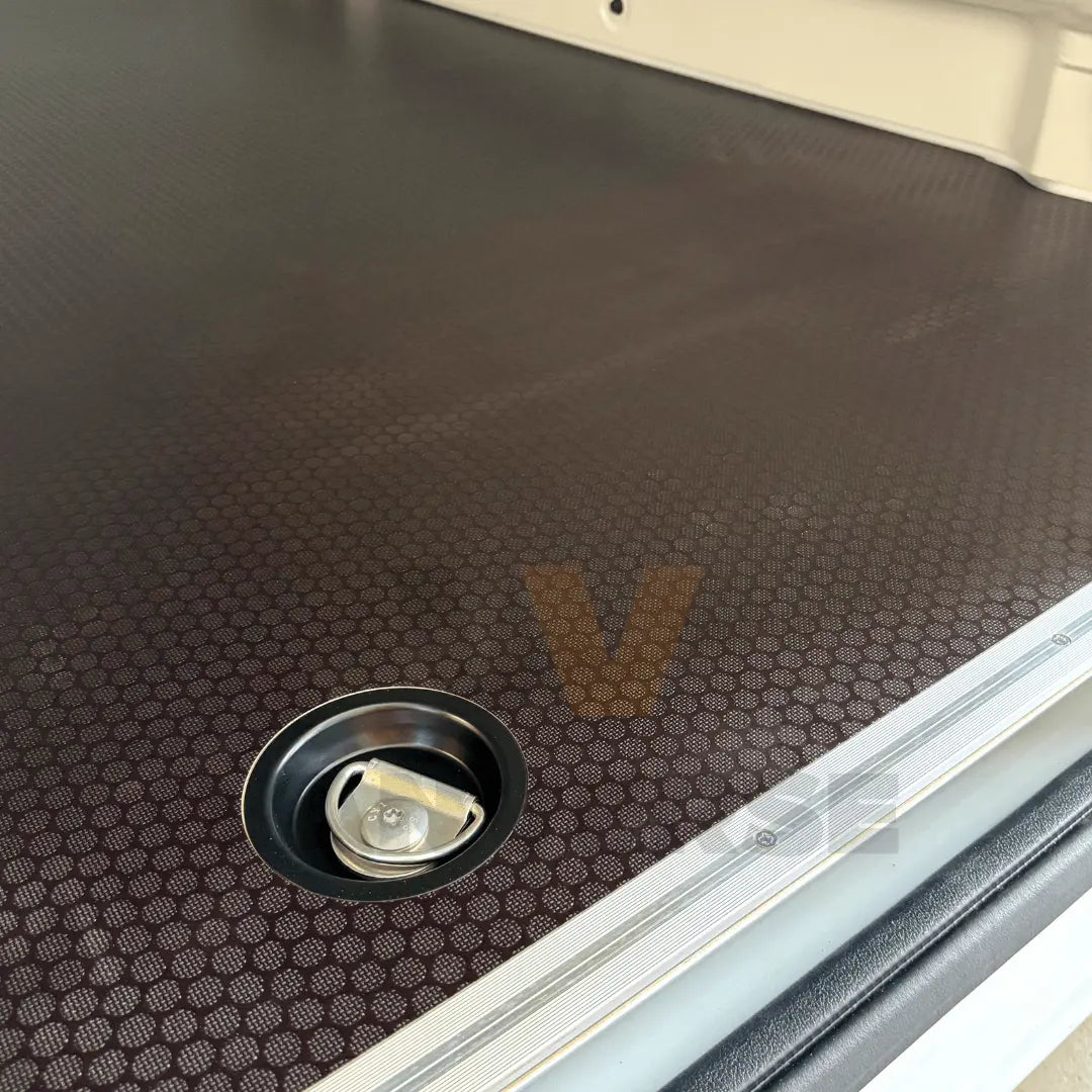 Primer plano de la anilla de amarre y del suelo fenólico marrón en furgoneta.