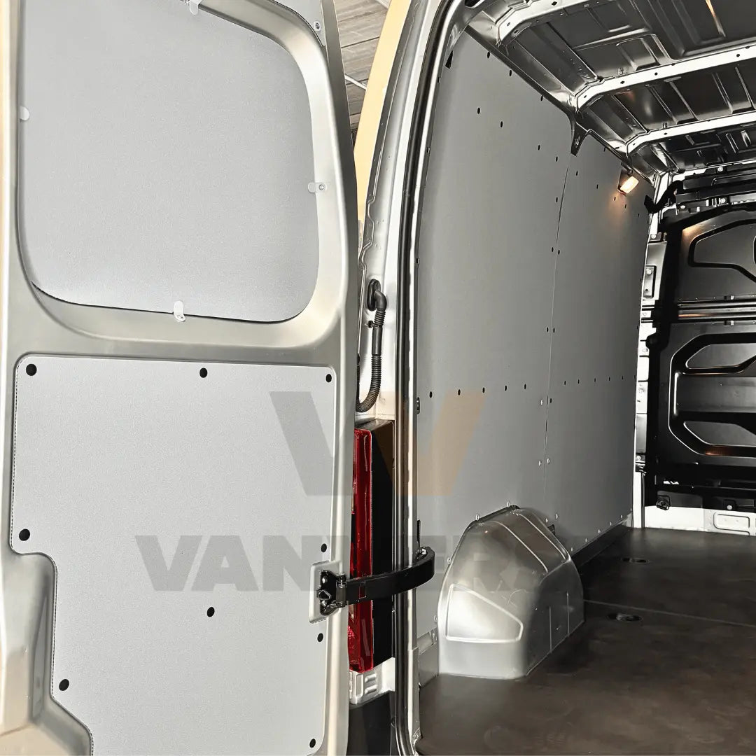Revestimiento lateral interior de contrachapado premium gris en furgoneta grande, diseñado para proteger la carrocería de golpes y desgaste.