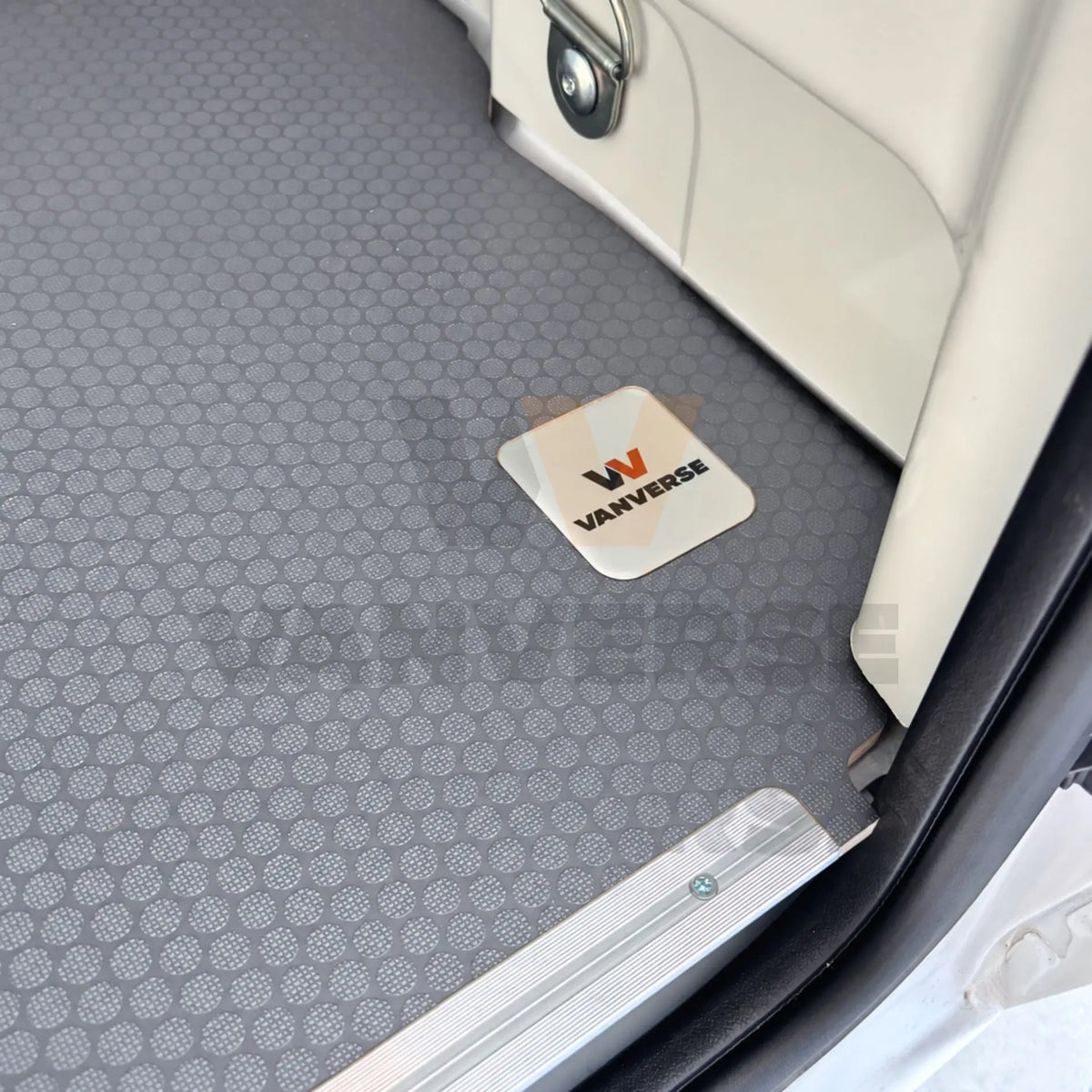 Detalle del suelo fenólico gris instalado, con textura antideslizante, perfil de aluminio y placa VanVerse.