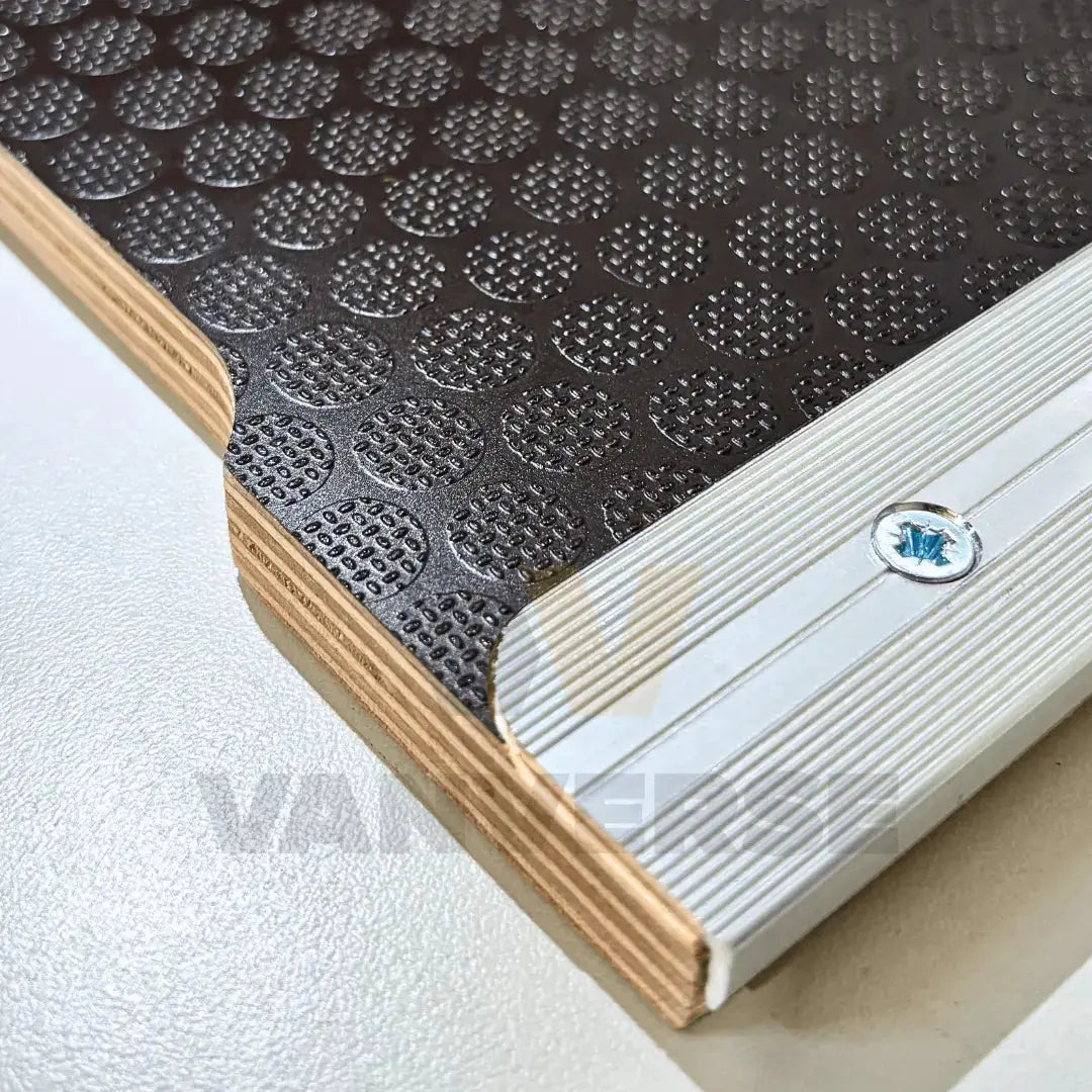 Suelo fenólico marrón con acabado madera, preparado para uso de alta intensidad en furgoneta.