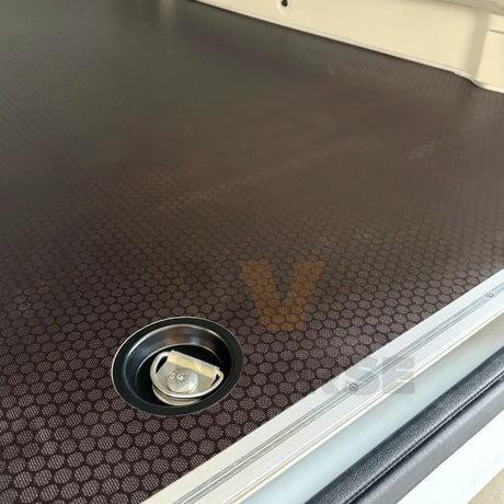 Primer plano de la anilla de amarre y del suelo fenólico marrón en furgoneta.