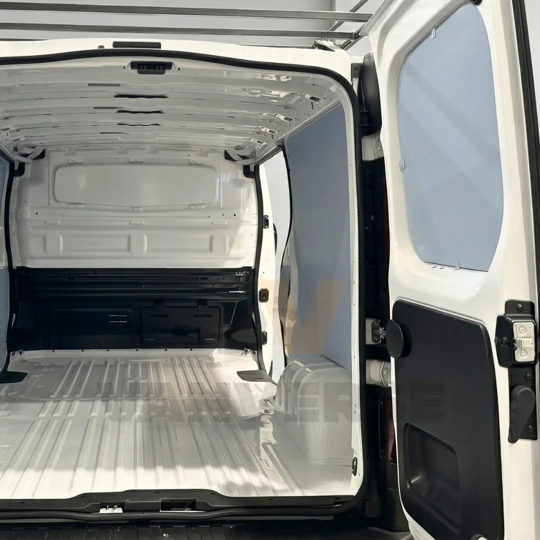Revestimiento lateral interior de contrachapado premium gris en furgoneta mediana, diseñado para proteger la carrocería de golpes y desgaste.