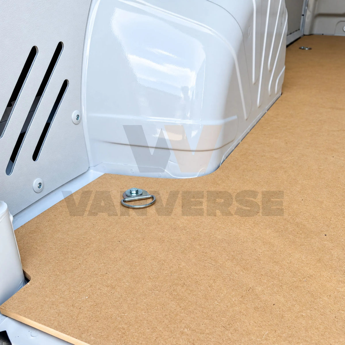 Detalle del suelo de madera DM instalado junto al paso de rueda y punto de anclaje de la furgoneta.