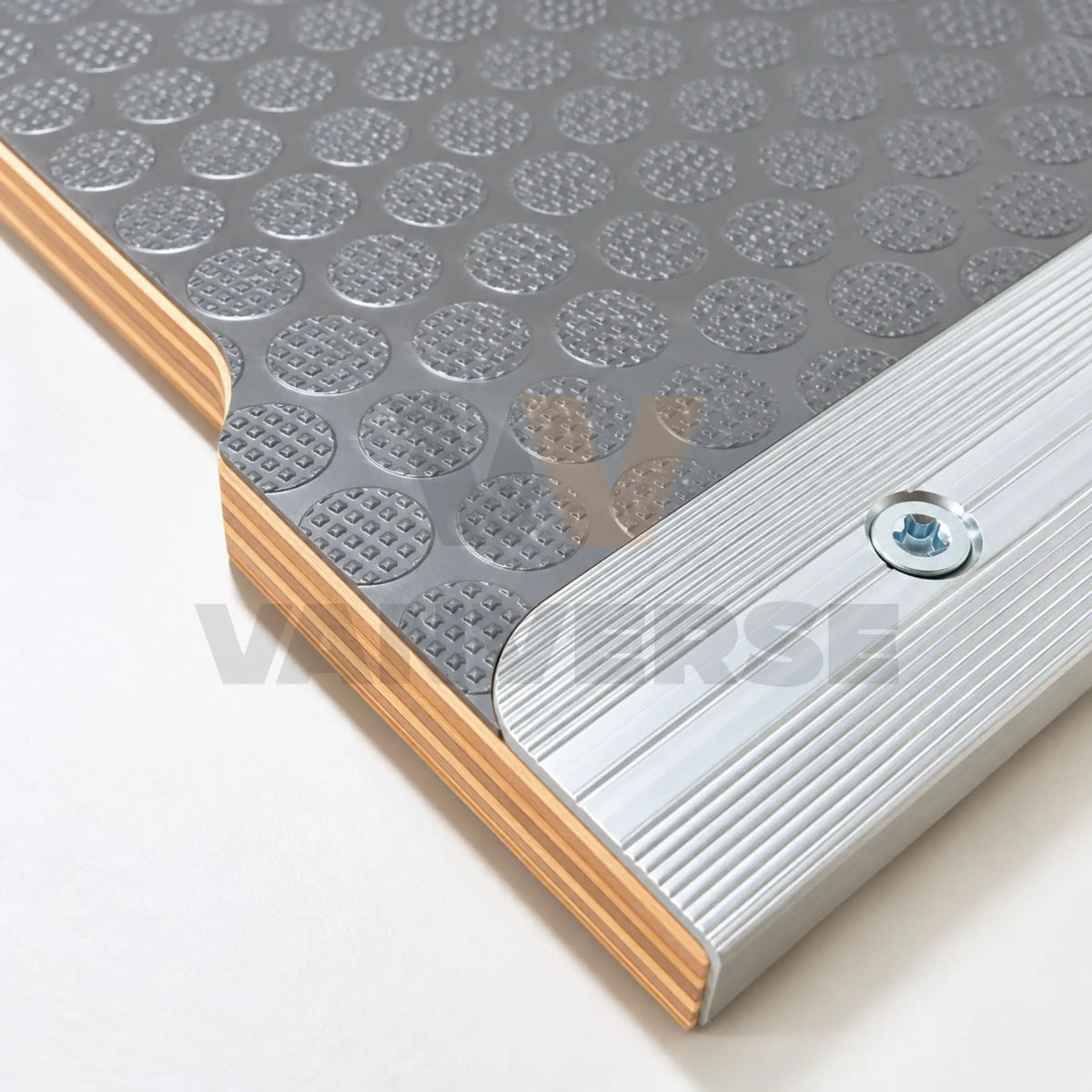 Detalle del tablero fenólico gris con textura antideslizante y perfil de aluminio fijado con tornillo.