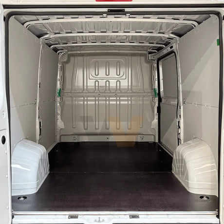 Suelo fenólico marrón preparado para uso intensivo en la zona de carga de una furgoneta grande.